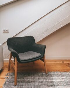 Stylish gray armchair in a contemporary attic with sloping ceilings and a cozy rug.