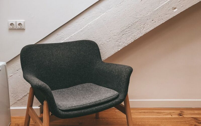 Stylish gray armchair in a contemporary attic with sloping ceilings and a cozy rug.